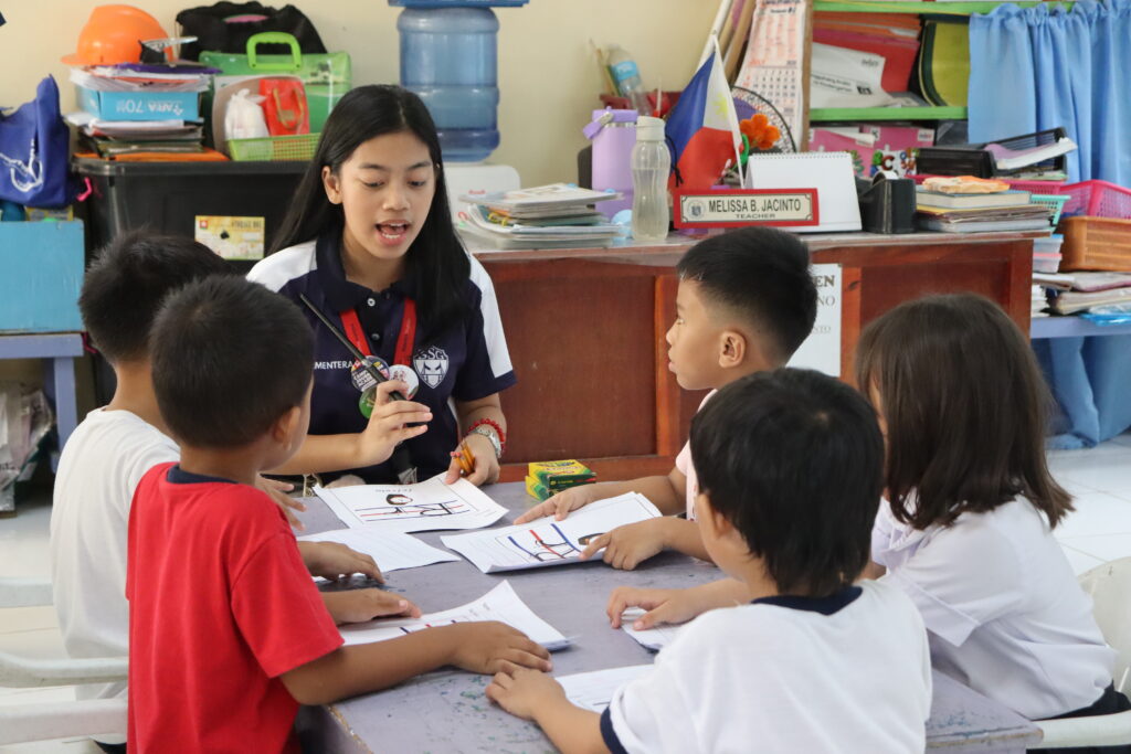 Volunteer assisting kids with worksheets