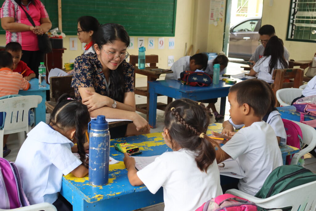 Volunteer assisting children in classroom