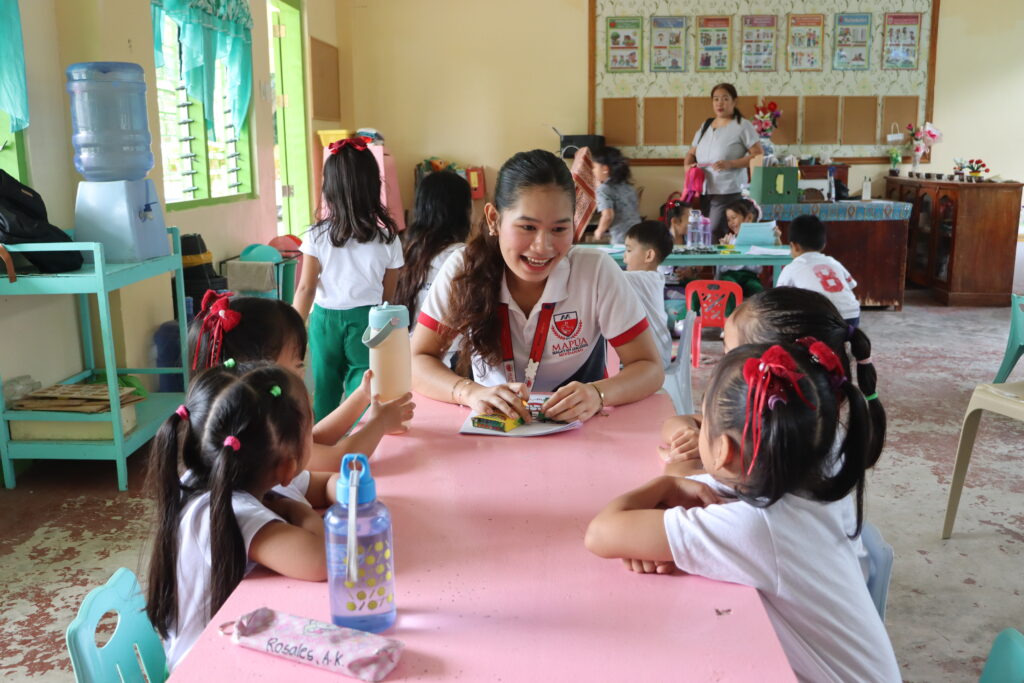 Volunteer guiding students at a table