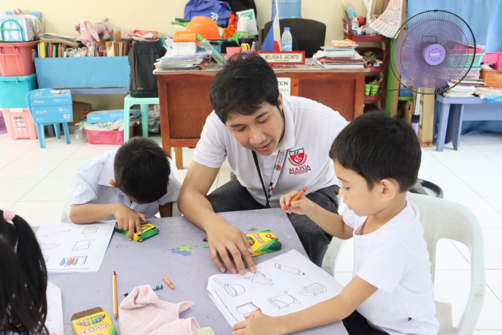 Volunteer working with students on worksheets