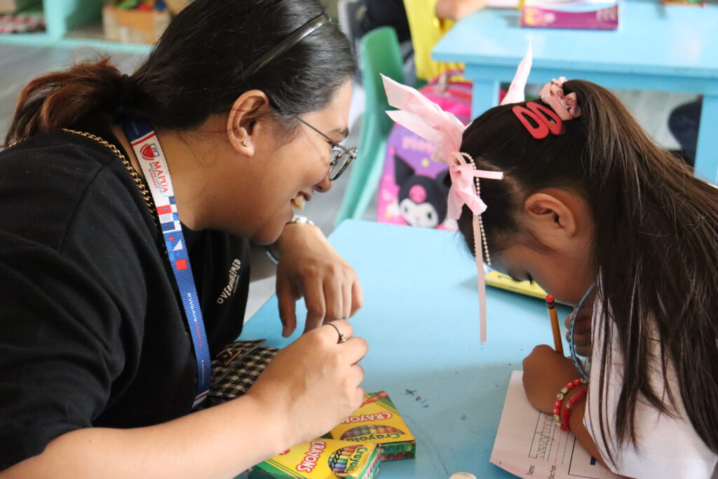 Volunteer assisting children with tasks