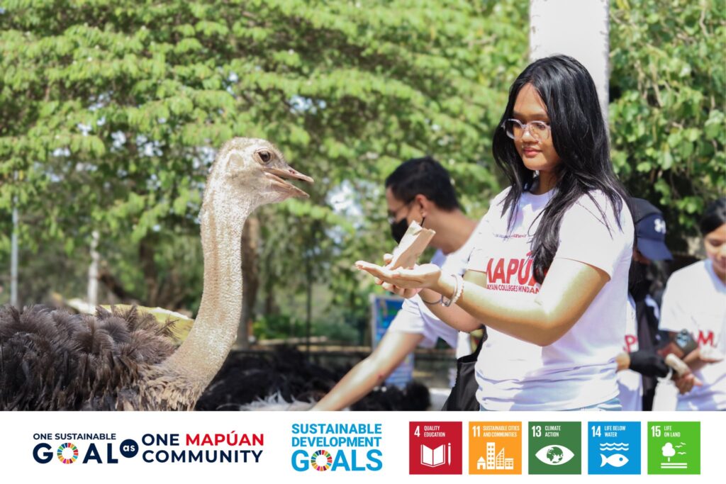 A student engaged in a close up encounter with an ostrich