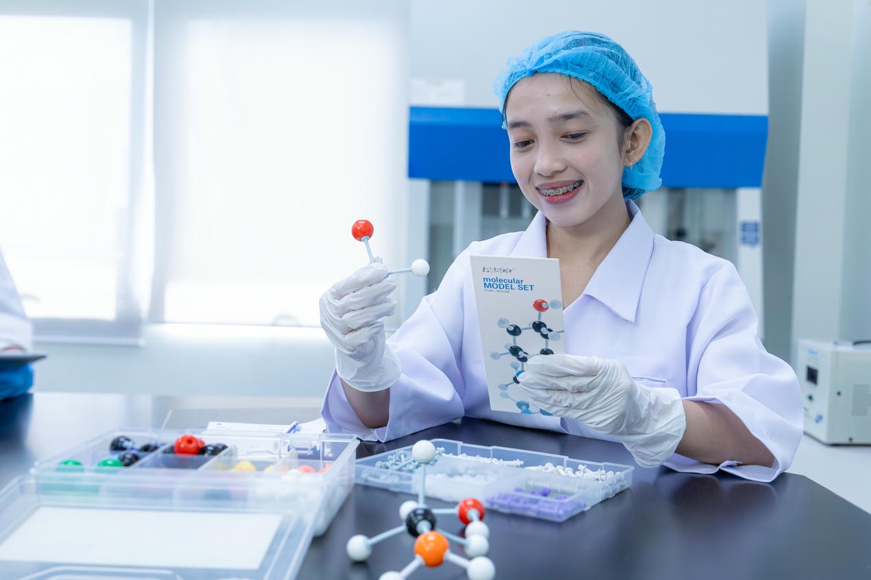 Smiling young female in science laboratory with model set | Mapúa Malayan Colleges Mindanao Smiling young female in science laboratory with model set